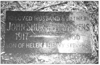 Two later stones lying flat beside vertical headstone.