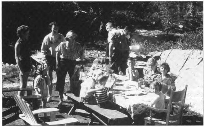 (Left to right back) Rose, Bobbie, Nancy, Willard and Lawton at a barbeque for (left to right front) Christie, Nan, Steve, Roy, Linda, Kathie, Sandy and Jeffrey—horseshoe pit and sparkling channel in background, Echo Lake, early 1950s.