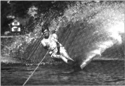 At Mermaid Cove the Millers purchased their first boat, a Correct Craft, which they named the PDQ. Here, Steve is jumping the wake with their home in the background, circa 1968-69