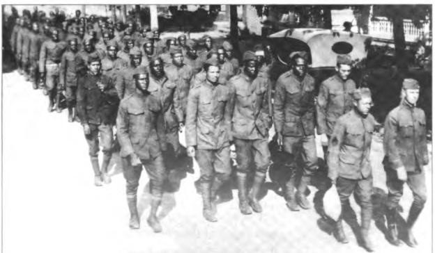 Harry (right) marching as com¬manding officer of a company of all black troops ready for discharge, circa 1919.