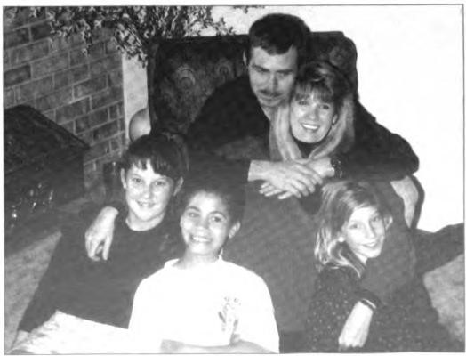 Steph and Rusty and their "blended" family, Christmas 1992. Her daughters, Jennifer (left) and Elizabeth (right), and Rusty's son, James Chase, Jr. (bot¬tom center).