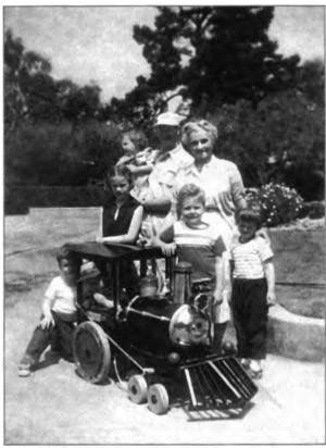 Billie and Don in 1957 with a bunch of neighborhood kids admiring Don's toy steam engine, that turned the Lawton backyard into a "Lawtonland" long before there was a Disneyland.